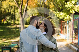 Love, relationship, family and people concept - smiling couple kissing in autumn park