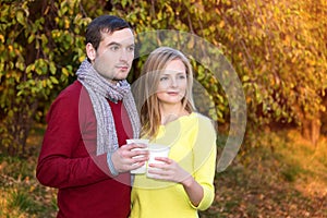 Love, relationship, season, friendship and people concept - happy man and woman enjoying golden autumn fall season with paper