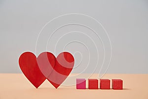 Love and relationship. Valentines Day. Couple in love. Amour, fondness. Two red hearts, wooden cubes mockup, copy space photo