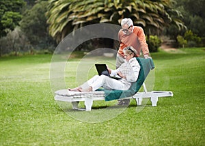 Love, relax and senior couple with laptop in garden for internet, search or communication while bonding. Social media