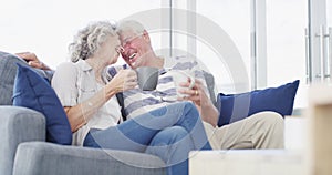 Love, relax and senior couple on a sofa with coffee break, connection and romance at home together. Support, gratitude