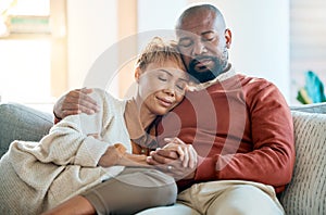 Love, relax and trust with a black couple on a sofa in the living room of their home together. Hug, marriage and romance