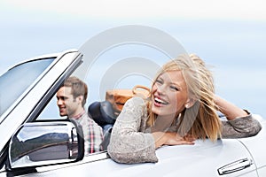 They love roadtrips. a young couple enjoying a drive in a convertible.
