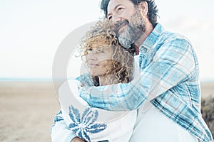 Love and romance adult couple hugging with care. Relationship people together with beach in background. Happy adults smile and