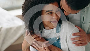 Love, romance and smile with a black couple hugging or sharing an intimate moment in their home together. Happy, care