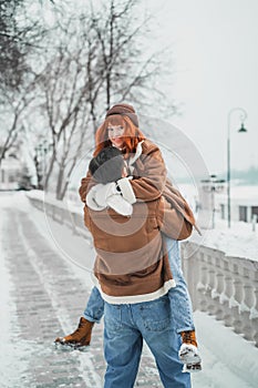 Love romantic couple lovestory. Brutal bearded man, bright red-haired girl woman in winter park. Romantic date, kissing