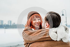 Love romantic couple lovestory. Brutal bearded man, bright red-haired girl woman in winter park. Romantic date, kissing