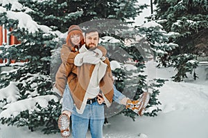 Love romantic couple lovestory. Brutal bearded man, bright red-haired girl woman in winter park. Romantic date, kissing