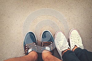 Love romantic couple - top view sneakers on the ground of man and woman feet in outdoor lifestyle