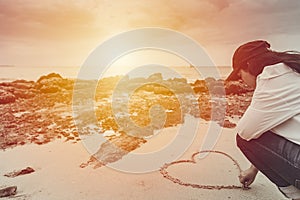 Love romantic teen draw heart on the summer beach