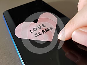 Love Scam awareness concept. A person holding bank card, ready to make transactions for scammer