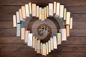 Love science concept. Books stacked in heart shape and molecule model on wooden desk. Take a degree in natural Sciences