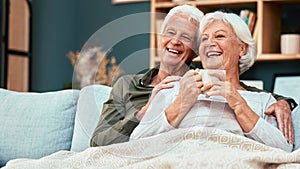 Love, senior couple relax on sofa drinking coffee and watching comedy movie on television. Retirement, old man and woman