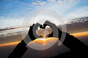 love shape hand silhouette in sky