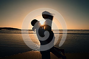 Love, silhouette and sunset with couple at beach for romance, affectionate and summer. Travel, happy and vacation with