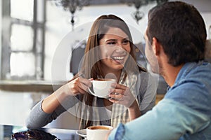 Love, smile and couple drinking coffee in cafe, care and bonding together on valentines day date. Happy man, woman in