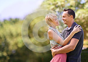 Love, smile and happy couple hug in park with trust, support or solidarity, security or bonding in nature. Commitment