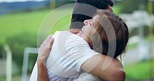 Love, smile and man hugging his senior mother outdoor in a park while on family vacation together. Happy, proud and male