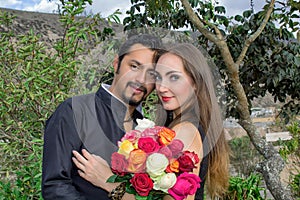 Love story. Man and woman hugging each other in nature in a blooming garden. With a bouquet of flowers.