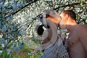 Love story. Spring couple in love. Summer happiness. Sensual lovers in cherry blossom tree.