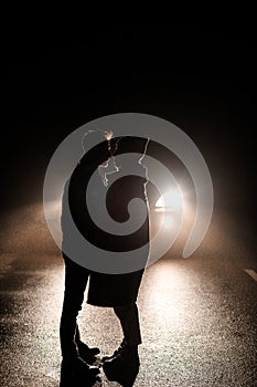 Love story in winter foggy forest. valentines concept. Silhouetted couples near the headlights of a car