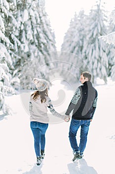 Love story in the winter forest. Young romantic couple outdoor. Valentine`s Day concept.