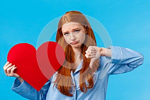 Love sucks. Upset and disappointed gloomy redhead girl in pyjama was rejected feeling uneasy and depressed, showing