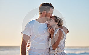 Love, summer and couple kiss at beach for intimacy, romance and loving relationship on honeymoon. Dating, affection and