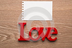 Love symbol written in wooden letter with message card