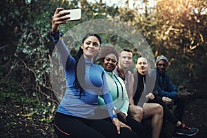 We love taking selfies during our workout. Cropped shot of a sporty young group of friends taking a selfie while taking
