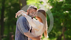 Love and tenderness. Happy couple in love embracing, enjoying closeness during walk at green summer park