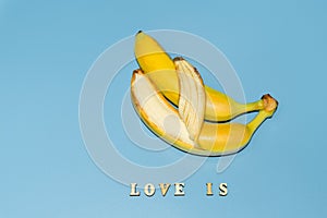 Love is a text of colored letters. Two bananas together, the concept of love and family relationships of opposite-sex marriages