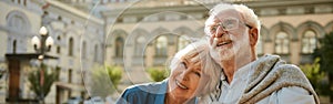 We love to travel together. Happy senior couple bonding to each other and smiling while standing outdoors