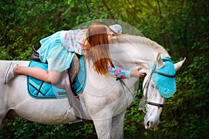 Redhead girl and white horse in the forest photo