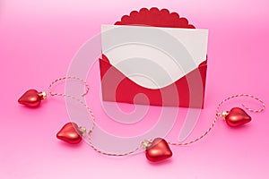 Love for Valentine's day - Red hearts hung together on the rope on pink background