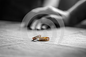 Love, Valentine`s day and wedding concept. Two wedding rings with man and woman hands blurred in the background. Selective focus