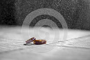 Love, Valentine`s day and wedding concept. Two wedding rings with man and woman hands blurred in the background. Selective focus