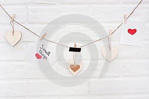 Love valentines garland with brick wall on a background. Wise phrase `small things`