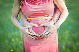 Love, waiting for the baby. Couple, pregnant woman and man, in colorful flying clothes, hold hands Pregnancy, maternity, preparati