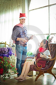 love, wedding, winter, dating and people concept - smiling couple in Play Ukulele.