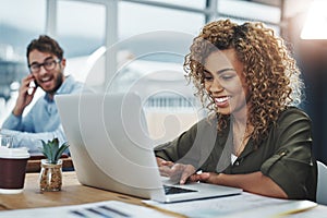 Love what you do and itll show in your work. a young woman working at her desk with her colleague in the background.