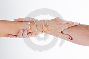 Love woman hands gripping man arm hanging on with jewelry bracelets