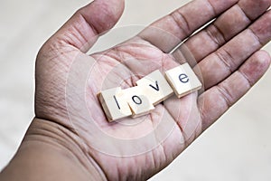 Love wooden blocks on Asian hand