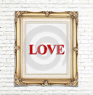 Love word in golden vintage photo frame on white brick wall,Love concept