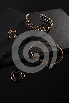 Love word shape bracelet and rings on black plates with copy space