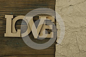 Love word, small hearts on dark wood background. Top view of Valentine`s Day