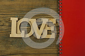 Love word, small hearts on dark wood background. Top view of Valentine`s Day