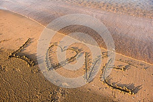 Love word written in sand