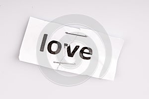 Love word written on torn and stapled paper