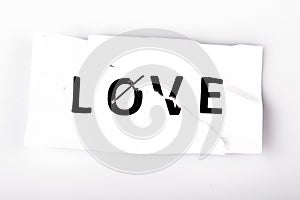 Love word written on torn and stapled paper on white